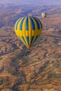 Hot air balloon flying over rocky landscape at sunrise - Cappadocia Turkey Royalty Free Stock Photo