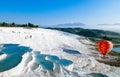 Hot air balloon flying over Travertine pools limestone terraces Royalty Free Stock Photo