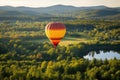 hot air balloon with forested landscape in the background