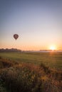 Hot air balloon lifts off over a farm field at sunrise, portrait Royalty Free Stock Photo