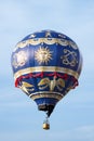 Hot air balloon moving up in blue sky.