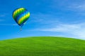 Hot air balloon over green field Royalty Free Stock Photo