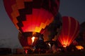 Hot air balloon pilots fire their burners during a night glow Royalty Free Stock Photo