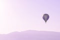 Hot air balloon in the pink sky above soft sunrise mountains silhouettes Royalty Free Stock Photo