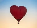 Hot Air Balloon in Red Heart Shape at sunset sky background