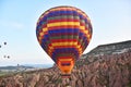 A Hot Air balloon floats over the Cappadocia landscape of Fairy Chimneys Royalty Free Stock Photo