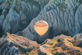 Hot air balloon rising over the Cappadocian valley with chimney houses in the background