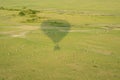 Hot air balloon shadow over the Masaai Mara Reserve, with antelope impala animals running in the grass. Aerial view, Kenya Africa