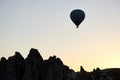 Hot air balloon silhouette in the morning sky by the fairy chimneys