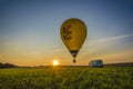 Hot air balloon during sunset and crew van