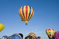 Hot-air balloons ascending over inflating ones