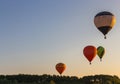 Hot air balloons in clear sky over forest. Colorful balloons on aerial landscape background. Summer leisure.