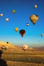 Hot air balloons festival in Cappadocia. Picturesque view of landing balloon on the valley after morning flight