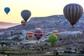 Hot air balloons float through the spectacular landscape around Goreme at sunrise in the Cappadocia region of Turkey.