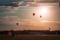 Hot air balloons floating through the air at sunset at an airshow