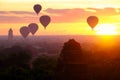 Hot air balloons fly over the ancient pagodas of old Bagan in Myanmar at sunrise. Royalty Free Stock Photo