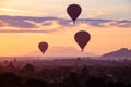 Hot air balloons fly over the ancient pagodas of old Bagan in Myanmar at sunrise. Royalty Free Stock Photo