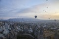 Hot air balloons flying over mountains landscape and the valley at Cappadocia in the sunrise sky at foggy morning Royalty Free Stock Photo