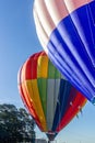 2 hot air balloons are almost fully inflated and ready to rise into the blue sky Royalty Free Stock Photo