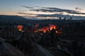 Colorful hot air balloons glowing while filling up with hot air. Mountain landscape in blue hour sunrise