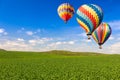 Hot Air Balloons Over Lush Green Landscape and Blue Sky Royalty Free Stock Photo