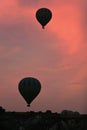 Hot Air Balloons Silhouettes Flying In Red Sky Above Valley