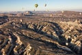 Hot air balloons in the sky during sunrise. Flying over colourful rock formations in Cappadocia, Turkey in Goreme.