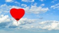 Hot air red ballon in the shape of heart against blue sky with w Royalty Free Stock Photo