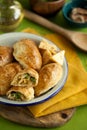 Hot appetizer for family dinner.baked puff pastry pies stuffed with chicken, cheese,pepper on wooden board and green background