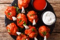 Hot appetizer Lollipops fried red chicken wings served with sauces close-up on a slate board. horizontal top view Royalty Free Stock Photo