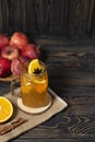 Hot apple honey punch or cider on dark wood background. Traditional fall or winter warming spicy beverage with cinnamon