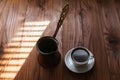 Hot aromatic coffee in a white porcelain cup on a saucer on a wooden table in the morning. Traditional Turkish coffee prepared in Royalty Free Stock Photo