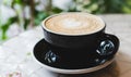 Hot art Latte Coffee in a cup on wooden table and Coffee shop blur background with bokeh image. Selective focus Royalty Free Stock Photo