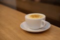 Hot art latte coffee in a white cup with a saucer on wooden table. Coffee shop blur background with bokeh image. Coffee Royalty Free Stock Photo