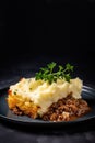 Hot baked homemade cottage Shepherd's traditional pie with greens on black with copy space Royalty Free Stock Photo