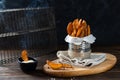 Hot Baked potato wedges with addition sea salt and pepper with sauce on a black background, side view, copy space Royalty Free Stock Photo