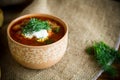 Hot beetroot soup with sour cream, herbs and rolls in a ceramic bowl Royalty Free Stock Photo