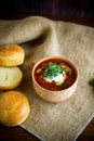 Hot beetroot soup with sour cream, herbs and rolls in a ceramic bowl Royalty Free Stock Photo