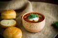 Hot beetroot soup with sour cream, herbs and rolls in a ceramic bowl Royalty Free Stock Photo