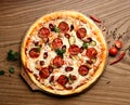 Hot big pepperoni pizza tasty pizza composition with melting cheese bacon tomatoes ham paprika steam smoke Royalty Free Stock Photo