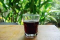 Hot black coffee in a clear glass is placed on yellow wooden table Royalty Free Stock Photo