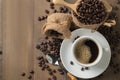 Hot black coffee on cup and roasted coffee beans in wood scoop o Royalty Free Stock Photo