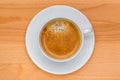 Hot black coffee with foam bubbles in white cup with wooden boar Royalty Free Stock Photo