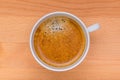Hot black coffee with foam bubbles in white cup with wooden boar Royalty Free Stock Photo