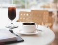 Hot black coffee mug on table at empty cafe/restaurant. Concept of loneliness, isolation, abandonment or solitary