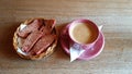 Hot black coffee in a pink cup and fresh bread in a basket Royalty Free Stock Photo