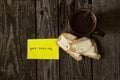 Hot black coffee and white bread and butter on an old wooden table and the words in English good morning on yellow paper Royalty Free Stock Photo