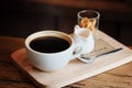 Hot black coffee in white cup Served with mini biscuit on rough wooden plate Royalty Free Stock Photo