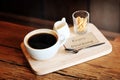 Hot black coffee in white cup Served with mini biscuit on rough wooden plate Royalty Free Stock Photo