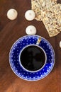 hot black morning espresso coffee in blue mug on brown wooden table and cookies with sunflower seeds. top view, flat lay vertical